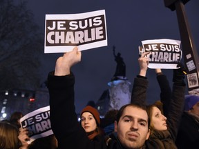 People hold placards reading in French "I am Charlie" during a gathering at the Place de la Republique (Republic square) in Paris, on January 7, 2015, following an attack by unknown gunmen on the offices of the satirical weekly, Charlie Hebdo.