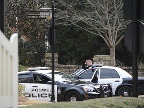 Roswell Police officers stand guard while blocking the street to the home of Bobbi Kristina Brown, daughter of Whitney Houston, during an investigation, Saturday. Brown was found unresponsive in her home Saturday morning and taken to North Fulton Hospital.