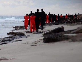 An image grab taken from a video released on Feb. 15, 2015 purportedly shows black-clad ISIS fighters leading handcuffed hostages, said to be Egyptian Coptic Christians, wearing orange jumpsuits before their alleged decapitation on a seashore in the Libyan capital of Tripoli.