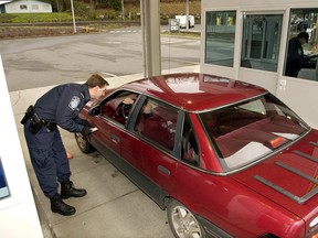 A U.S. Customs and Border Protection officer checks vehicles entering the United States.