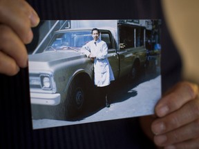 Keith Quan holds up a photograph of himself and his grocery delivery truck in Vancouver, British Columbia.