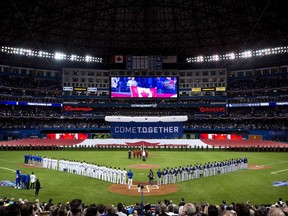 Toronto Blue Jays and Tampa Rays players line up and as they listen to the Canadian anthem during the home opener in Toronto in 2015.