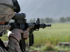 A Canadian Forces soldier on a reconnaissance patrol looks through his scope to check for insurgent activity in the village of Regay, Afghanistan on April 30, 2010.