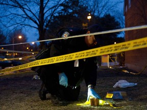 A police officer marks evidence at the scene of an earlier shooting near Driftwood and Finch Avenues in Toronto, from April.