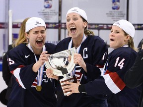 In this 2015 file photo, U.S. women's hockey players Alex Carpenter, Meghan Duggan and Brianna Decker celebrate their gold medal at that year's world championships.