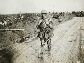 A muddy and exhausted Canadian soldier walks back from the front line after the battle of Vimy Ridge.