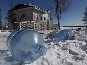 Empty 20 litre water bottles sit outside a house waiting for pickup and refilling. The Shoal Lake community, despite supplying water to the city of Winnipeg, is under a boil water advisory and lacks year round road access.