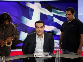 Alexis Tsipras, Greece's prime minister, center, takes his seat for a televised interview inside a studio of Greek state television broadcaster ERT in Athens, Greece, on Monday, June 29, 2015. Greek Prime Minister Alexis Tsipras said European leaders donít have the nerve to throw his country out of the euro, striking a defiant tone just hours after imposing capital controls on a country in economic freefall. Photographer: Yorgos Karahalis/Bloomberg *** Local Caption *** Alexis Tsipras