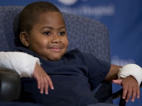Double-hand transplant recipient eight-year-old Zion Harvey smiles during a news conference Tuesday, July 28, 2015, at The Childrenís Hospital of Philadelphia (CHOP) in Philadelphia. Surgeons said Harvey of Baltimore who lost his limbs to a serious infection,  has become the youngest patient to receive a double-hand transplant. (AP Photo/Matt Rourke)