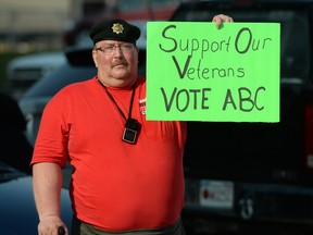 A veteran protests outside the Royal Canadian Legion as Conservative  leader Stephen Harper makes a campaign  stop in Fredricton, New Brunswick on Monday, August 17, 2015. ABC stands for "anything but Conservative."  THE CANADIAN PRESS/Sean Kilpatrick