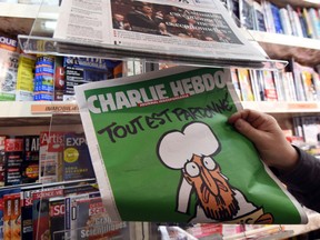 TO GO WITH AFP STORY BY TUPAC POINTU (FILES) - A man displays the latest edition of French satirical magazine Charlie Hebdo shortly after it went on sale on January 14, 2015 in Montpellier. The first issue of satirical magazine Charlie Hebdo to be published since a jihadist attack decimated its editorial staff last week was sold out within minutes at kiosks across France. AFP PHOTO / PASCAL GUYOTPASCAL GUYOT/AFP/Getty Images