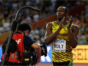 Jamaica's Usain Bolt applauds after finishing in first in a semifinal of the men's 100m at the World Athletics Championships at the Bird's Nest stadium in Beijing, Sunday, Aug. 23, 2015.