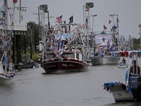 Boats line up in Bayou Terre aux Boeufs during the blessing of the fleet in Delacroix, La., Saturday, Aug. 8, 2015. It was the first blessing of the fleet since the coastal fishing and shrimping community was devastated by Hurricane Katrina a decade ago. (AP Photo/Gerald Herbert)