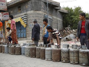 Yemeni people stand in a line to buy a canister of gas at a street in Sanaa, Yemen, Tuesday, Aug. 18, 2015. The Saudi-imposed blockade has created severe shortages of gas, petrol, and other goods, causing prices to skyrocket. (AP Photo/Hani Mohammed)