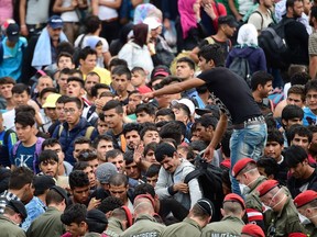 Refugees crowd at the Hungarian-Austrian border in Szentgotthard, Hungary, as thousands of migrants wait for their departure to Germany on September 19, 2015.