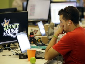 In this Sept. 9, 2015, photo, Devlin D'Zmura, a tending news manager at DraftKings, a daily fantasy sports company, works on his laptop at the company's offices in Boston.