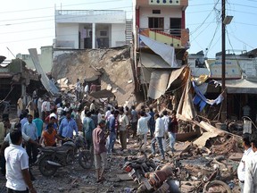 A crowd gathers at the site of an explosion in Petlawad, in the central Indian state of Madhya Pradesh, Saturday, Sept. 12, 2015. Dozens of people were killed at a restaurant in central India on Saturday when a cooking gas cylinder exploded and triggered a second blast of mine detonators stored illegally nearby, police said. (AP Photo/Manoj Jani)