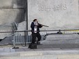 A tourist snaps a photo of Michael Zehaf-Bibeau pointing his rifle at the National War Memorial.