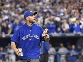 A Rogers Centre employee picks up beer cans thrown on the field by fans during last year's seventh inning game five American League Division Series baseball action between the Texas Rangers and the Toronto Blue Jays in Toronto on Wednesday, Oct. 14, 2015.