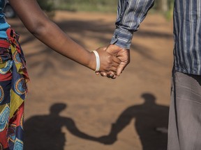 In this photo taken Wednesday, Nov. 18, 2015 a 15-year-old pregnant girl holds hands with her 20-year-old husband-to-be in Guibombo, some 40 kilometers from the city of Inhambane, Mozambique.