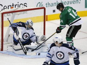 Winnipeg Jets' Mathieu Perreault looks back to see  goalie Ondrej Pavelec fighting off an attack by Dallas Stars' Jamie Benn in the third period of game Thursday night in Dallas. Benn scored on the play, helping the Stars to a 6-3 win.