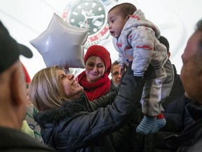 Tima Kurdi, left, who lives in the Vancouver area, lifts up her 5-month-old nephew after her brother and his family, who escaped conflict in Syria, arrived at Vancouver International Airport, on Dec. 28, 2015. Kurdi's three-year-old nephew, Alan Kurdi, drowned along with his five-year-old brother and their mother while crossing the waters between Turkey and Greece in September 2015.