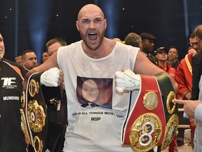 In this Nov. 29, 2015 file photo, Tyson Fury celebrates with the WBA, IBF, WBO and IBO belts after winning the world heavyweight title fight against Wladimir Klitschko in Dusseldorf, Germany.
