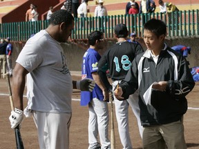 Gil Kim, then an international scout with the Texas Rangers, with chats with a player before a Mexican summer league game in Guanajuato in 2010. Kim was hired this week as the Blue Jays' first director of player development.