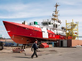 A worker walks past a Hero-class patrol vessel at the Irving shipyard in Halifax in October 2012.