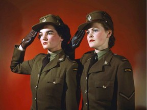 Two Second World War-era soldiers in the Canadian Women’s Army Corp salute with the traditional open palm British salute.
