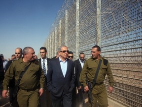 Israeli Prime Minister Benjamin Netanyahu (C) visits the construction site of a new military border fence between Israel and Jordan, on February 9, 2016