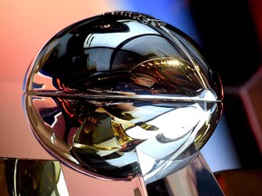 A fan is reflected in the Vince Lombardi Trophy at the NFL Experience in San Francisco, a day before the Carolina Panthers and the Denver Broncos play Super Bowl 50. When the 51st airs this February, maybe Canadians want to see their own country's ads, Colby Cosh muses.