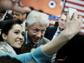 Bill Clinton, former U.S. President and husband of 2016 Democratic presidential candidate Hillary Clinton, center, takes a selfie photograph with supporters after speaking at a campaign rally at West End Community Development Center in Greenville, South Carolina, U.S., on Tuesday, Feb. 16, 2016.