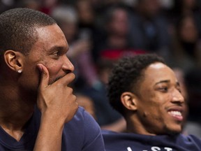 Miami Heat's Chris Bosh, left, laughs with former teammate Toronto Raptors' DeMar DeRozan (on the Eastern Conference bench) during first half of NBA All-Star Game in Toronto on Sunday.