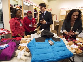 Justin Trudeau, centre, before the arrival of the first government-sponsored Syrian refugees at Pearson International airport in Toronto on Dec. 10, 2015.