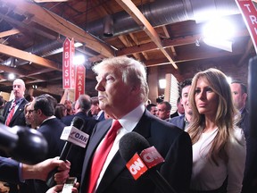 Republican presidential candidate, businessman Donald Trump with his wife Melania Trump at right,  speaks to the media in the spin room after the CBS News Republican presidential debate at the Peace Center, Saturday, Feb. 13, 2016, in Greenville, S.C.