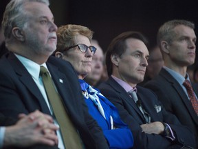 Ontario Premier Kathleen Wynne and Quebec Premier Phillippe Couillard listen to a speech by Prime Minister Justin Trudeau  in Vancouver.