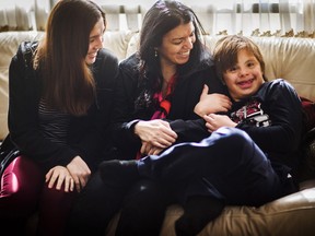 Nico Montoya, a 13-year-old boy with Down syndrome, sits on the couch at his home with his mother Alejandra Garcia, centre, and his sister Tania at their home in Richmond Hill.