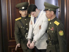 American student Otto Warmbier, center, is escorted at the Supreme Court in Pyongyang, North Korea, Wednesday, March 16, 2016.