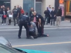 Toronto police arrest a suspect south of Yonge and Wellesley streets Friday.