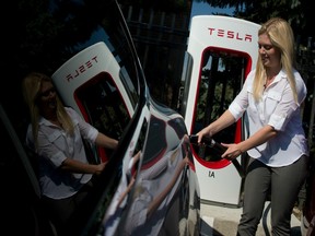 Alexis Georgeson demonstrates how to charge a Tesla model S electric car during a ribbon-cutting in 2014 for Tesla's first Ontario supercharger stations.