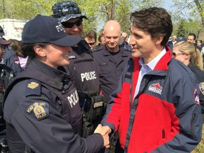 In this image released by the Alberta Royal Canadian Mounted Police (RCMP), Canadian Prime Minister Justin Trudeau speaks with RCMP officers during his visit to Fort McMurray on May 13, 2016.
Wildfires at Fort McMurray have wrought extensive devastation and led to the evacuation of thousands of residents.