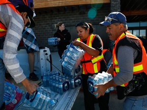 Volunteers load water for evacuees from the Fort McMurray wildfires at the evacuation centre in Lac la Biche, Alta., on Friday.