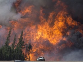 A giant fireball is seen as a wildfire rips through the forest 16 kilometres south of Fort McMurray, Alta. on Highway 63 Saturday, May 7, 2016. THE CANADIAN PRESS/Jonathan Hayward ORG XMIT: JOHV119