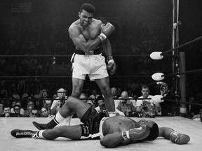 In this May 25, 1965 file photo, heavyweight champion Muhammad Ali stands over fallen challenger Sonny Liston, shortly after dropping Liston with a short hard right to the jaw in Lewiston, Maine. In 1964 he dropped the name Cassius Clay and adopted his Muslim name.