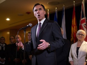 Federal Finance Minister Bill Morneau is flanked by his provincial and territorial counterparts as he speaks about expanding the Canada Pension Plan in Vancouver on  June 20, 2016.