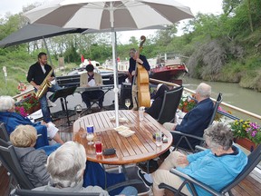 Guests aboard the luxury hotel barge Anjodi enjoy pre-dinner music on a 75-kilometre voyage along the Midi Canal in France's scenic and historic Languedoc region.