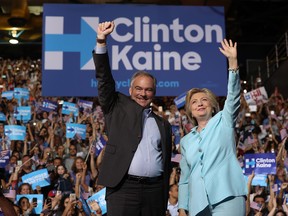 Democratic presidential candidate former Secretary of State Hillary Clinton and Democratic vice presidential candidate U.S. Sen. Tim Kaine (D-VA) greet supporters during a campaign rally at Florida International University Panther Arena on July 23 in Miami, Florida.