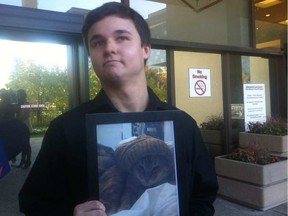 Derek North holds a picture of his cat Pudge outside the Law Courts on Oct. 7, 2014.