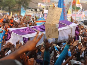 Supporters of Congo opposition leader Etienne Tshisekedi carry a symbolic casket during a protest against a third term for Congo President Joseph Kabila, during a political rally in Kinshasa, Congo, Wednesday, July 31